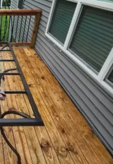 Golden brown deck boards next to a house window