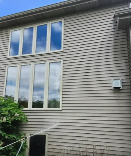Two storey house with beige siding and large windows