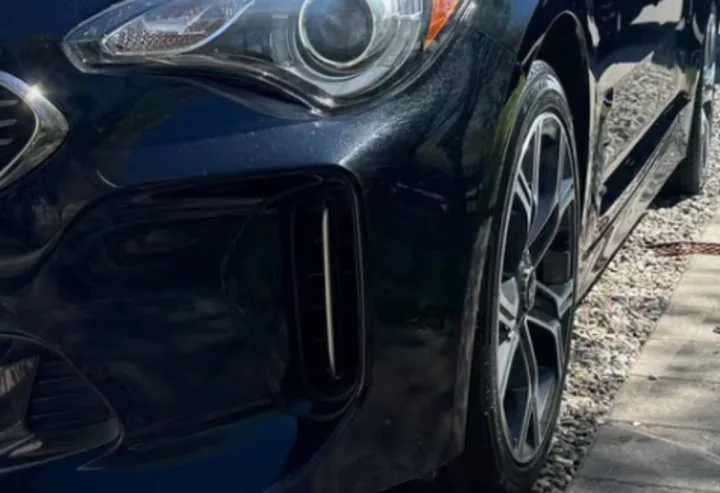 Clean black car wheel and glossy fender after detailing